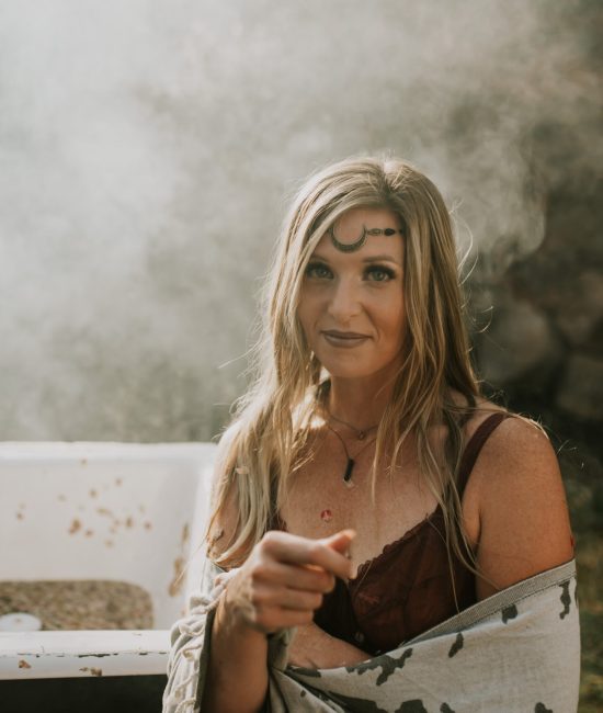 A woman in the the woods with a steamy bath and a moon forehead charm
