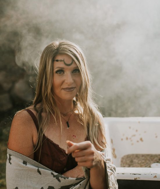 A woman in the the woods with a steamy bath and a moon forehead charm