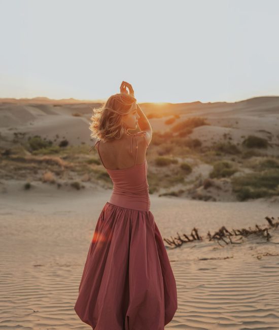 girl gazing into the sunset at the sand dunes near Salt Lake City